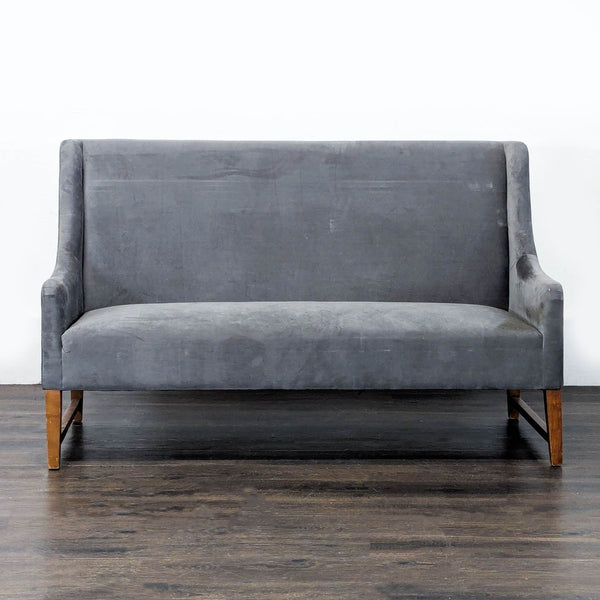 Modern grey Pier One loveseat with soft upholstery, sturdy wooden legs, and a minimalist design, seats two people.