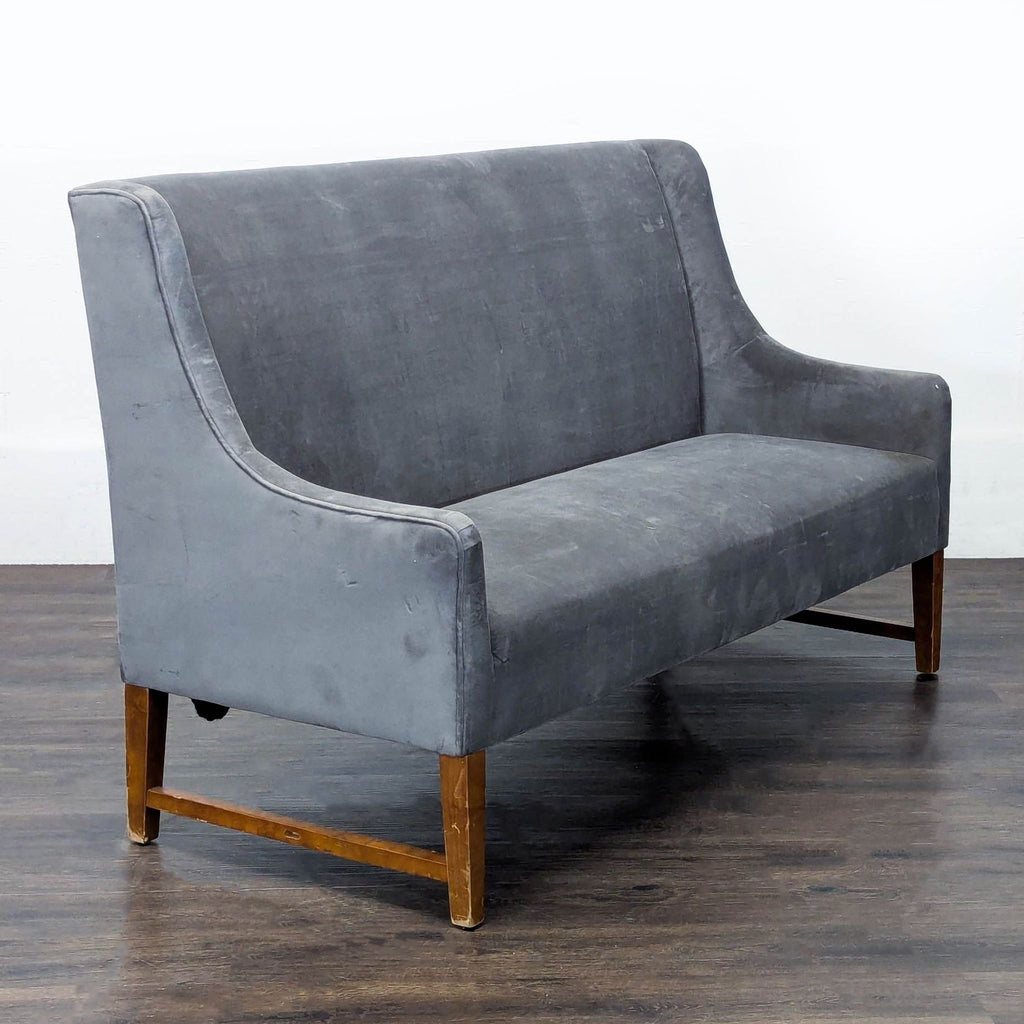 Contemporary Pier One loveseat in grey fabric, featuring clean lines and spacious seating for two; ideal for living rooms.