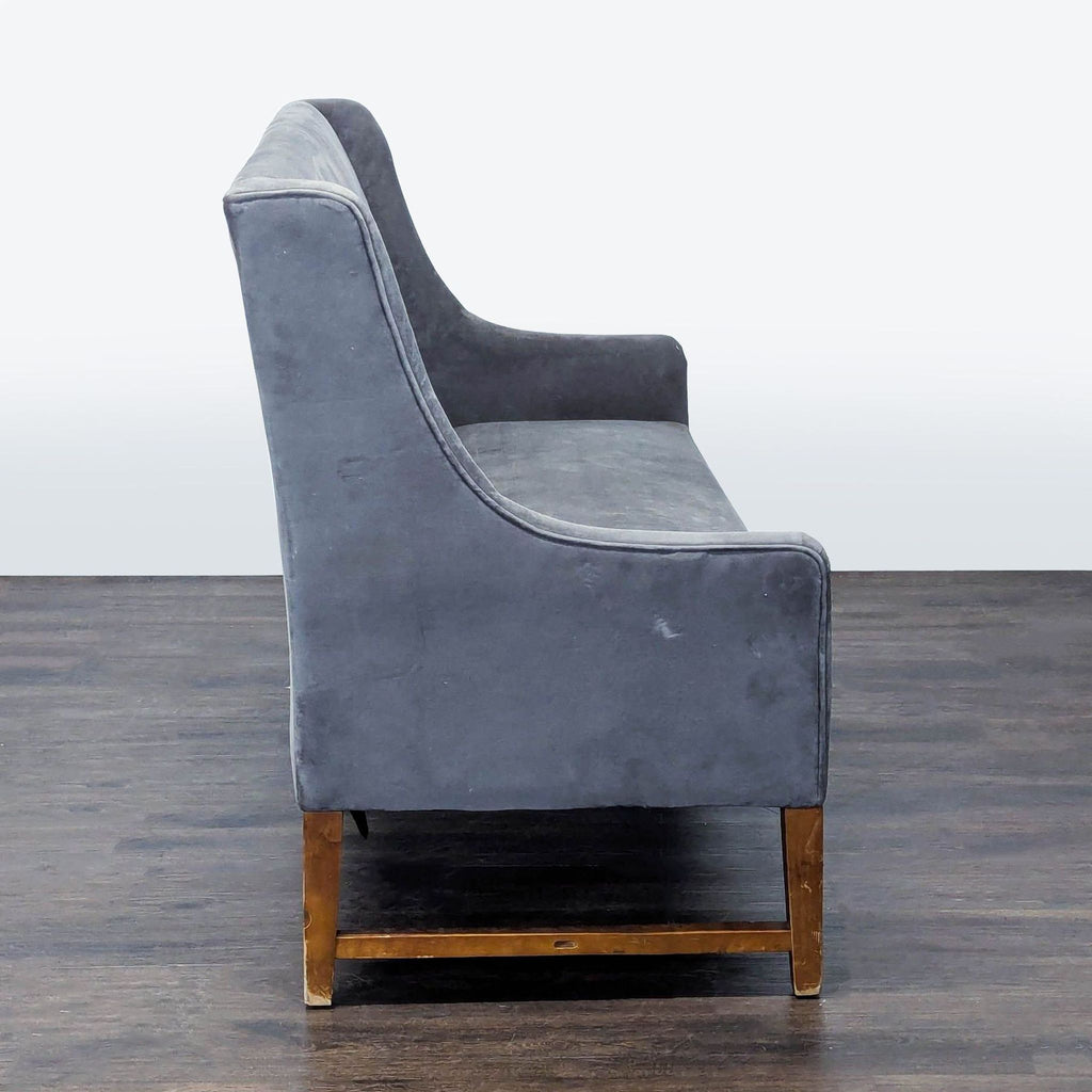 Pier One brand modern loveseat, upholstered in grey with wooden legs and sleek design, perfect for homes or offices.