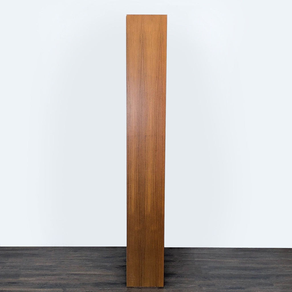 Side view of the Scandinavian Designs bookshelf highlighting its narrow, space-saving silhouette in a teak finish.