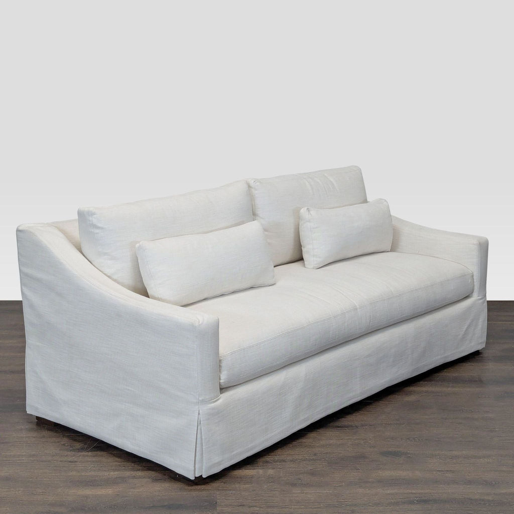 Modern white Restoration Hardware loveseat, featuring clean lines, extra pillows, and a tailored skirt, gently used.  