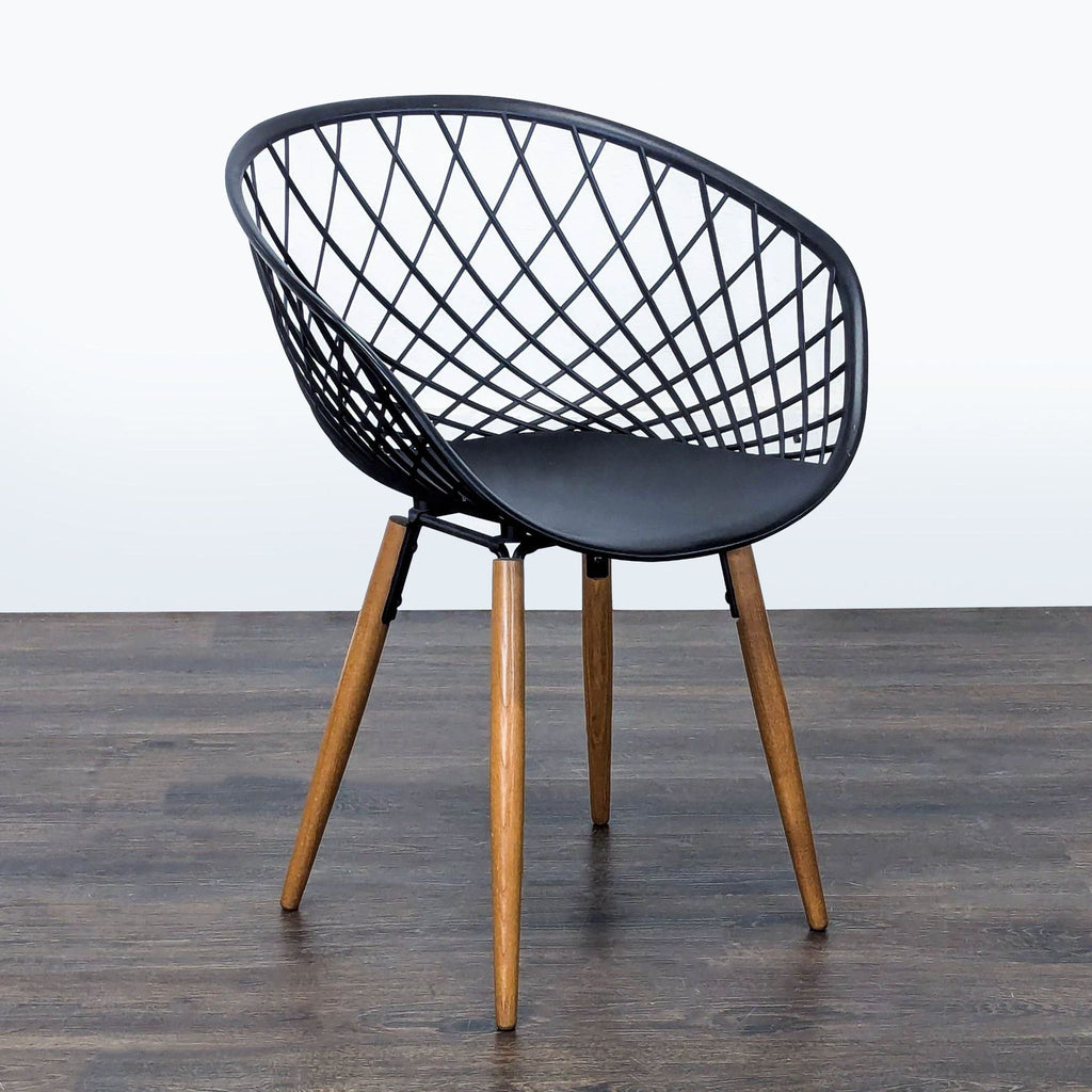 CB2 dining chair featuring a matte black crosshatch seat on tapered solid ash legs stained light to medium brown.