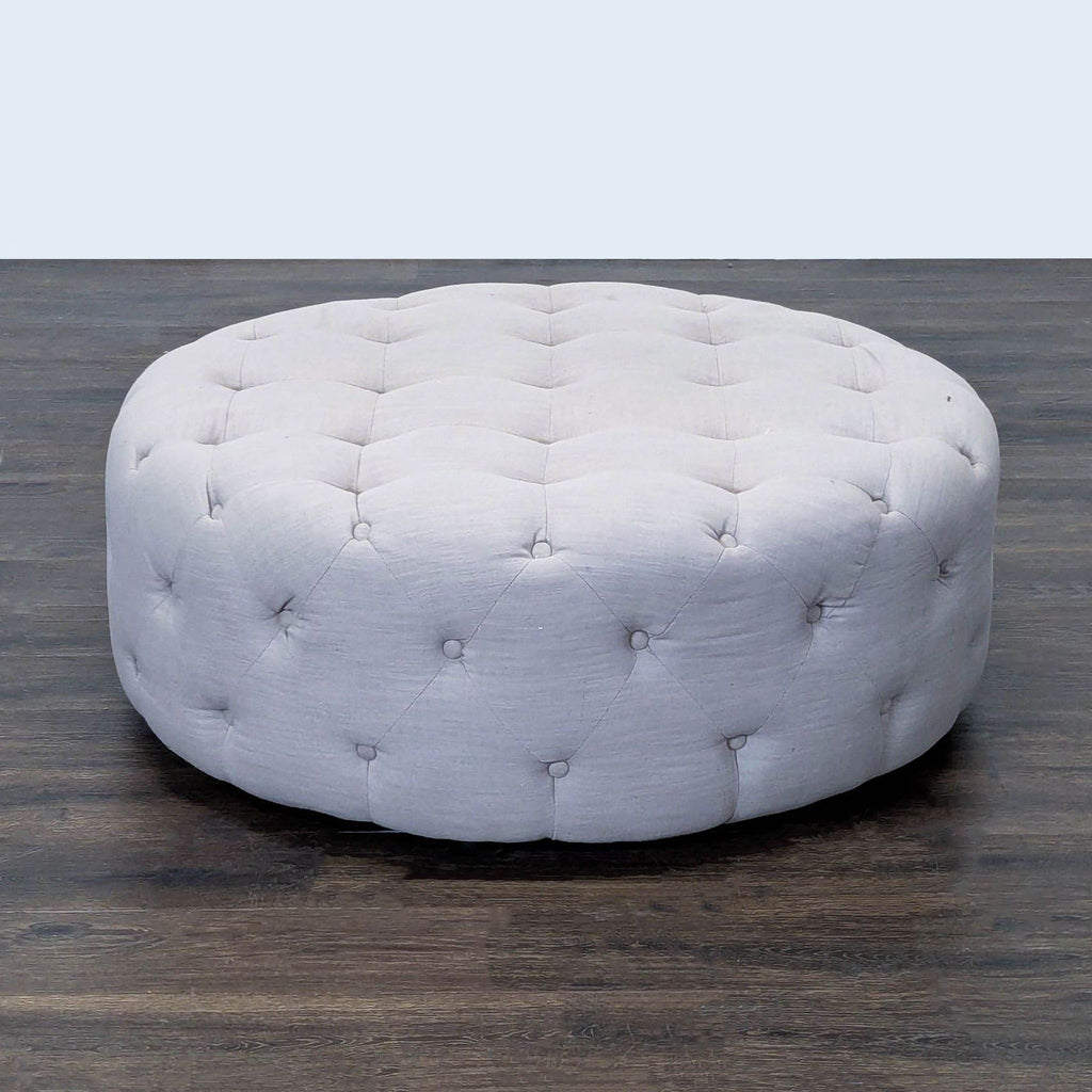 2. Plush gray round ottoman with button-tufted details, viewed slightly from above.