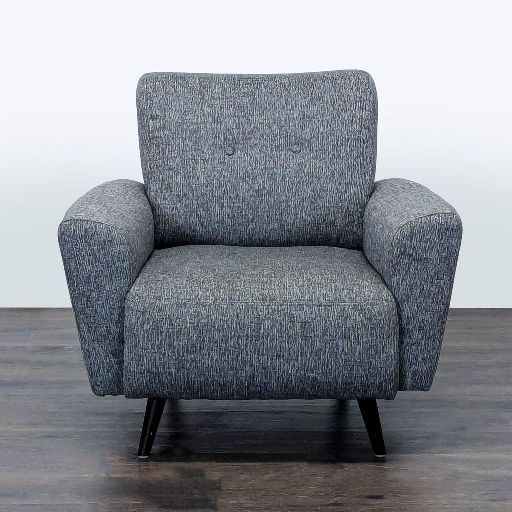 Grey lounge chair with padded seat and sturdy legs, ideal for relaxing in modern living spaces.