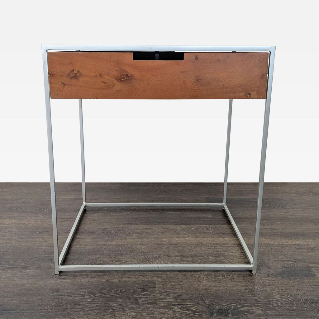 Minimalist CB2 end table featuring a wood drawer and sleek metal frame design.  