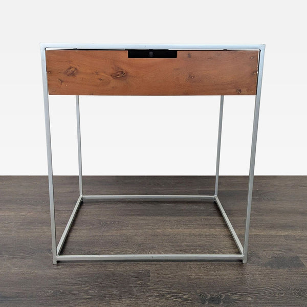 Minimalist CB2 end table featuring a wood drawer and sleek metal frame design.  