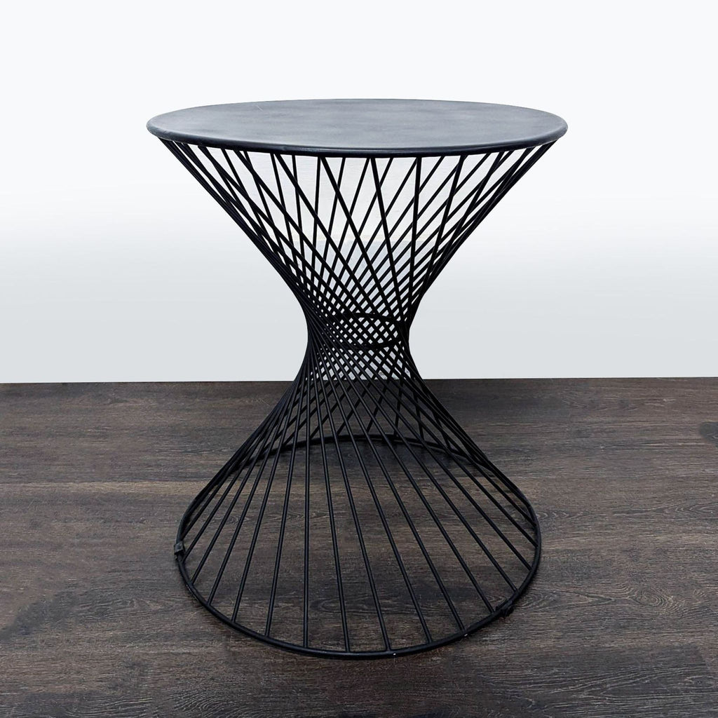 Modern accent table with black wire hourglass frame and round top, ideal for living rooms or bedrooms.