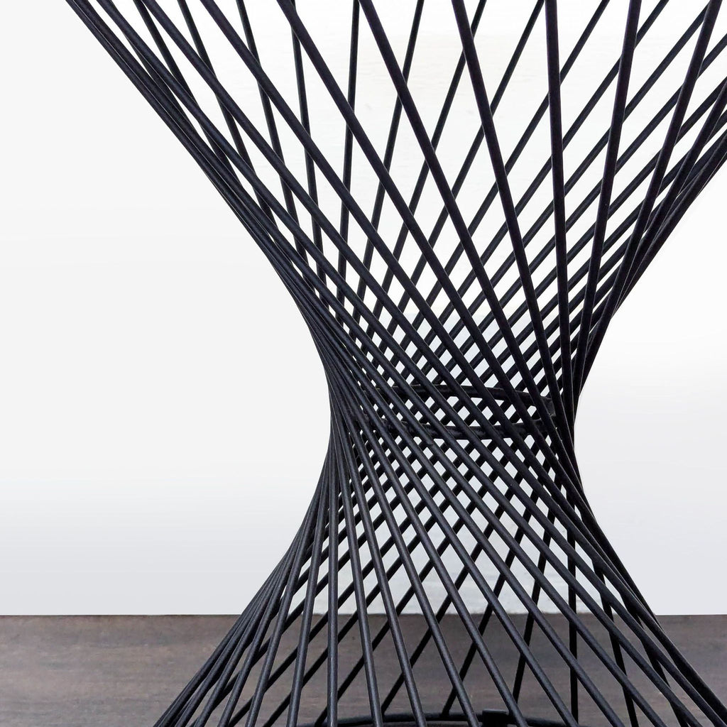 Contemporary side table featuring an open, lightweight metal base and smooth circular surface.