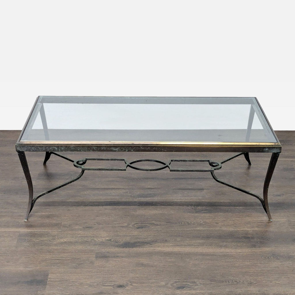 Glass-top Hollywood Regency table with gilded trim, patina cabriole legs, and geometric center stretcher.