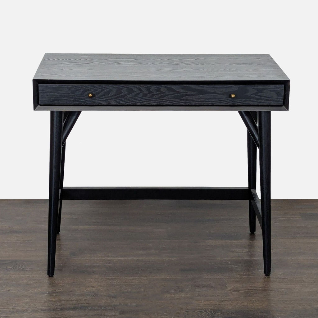 Minimalist black wooden West Elm desk with spacious top, pull-out drawer, and sturdy legs for home or office use.
