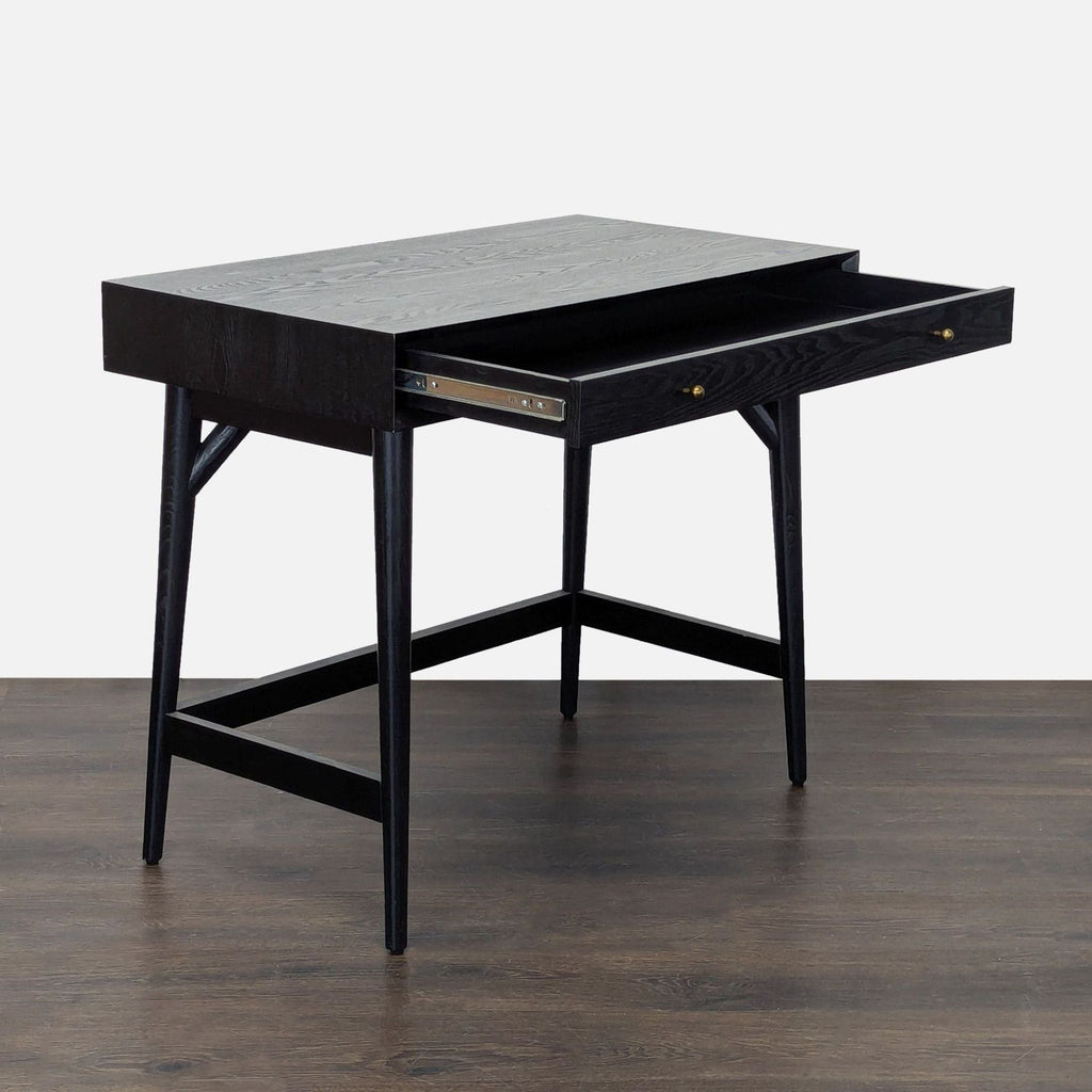 Modern black desk by West Elm featuring clean lines, a wide drawer, and stable legs for efficient workspace organization.