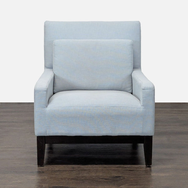 Modern West Elm lounge chair in light blue upholstery with dark wood legs and plush cushioning.