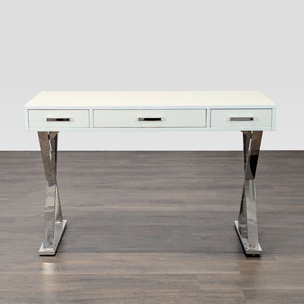Modern white Pottery Barn desk with chrome legs and three drawers, ideal for stylish home or office spaces.