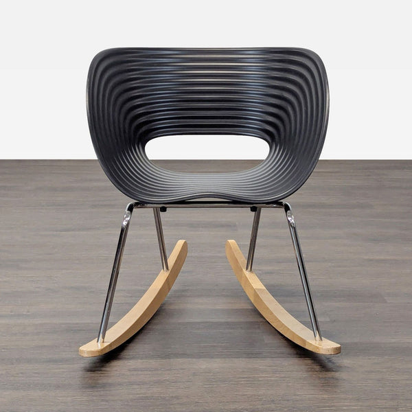 Vitra lounge rocker with black contoured seat, chrome frame, and wooden rockers for modern comfort.  