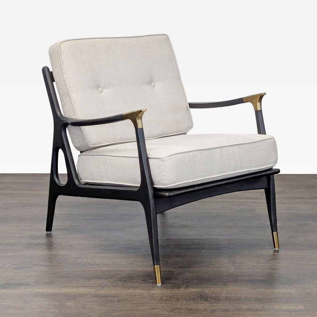 Anthropologie lounge chair featuring a sleek black frame, brass details, and cozy cream-colored cushions.  