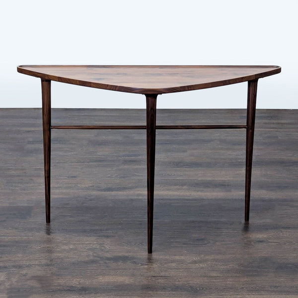 Triangular walnut side table with rounded edges, flat back, and slim tapered legs by Joybird.