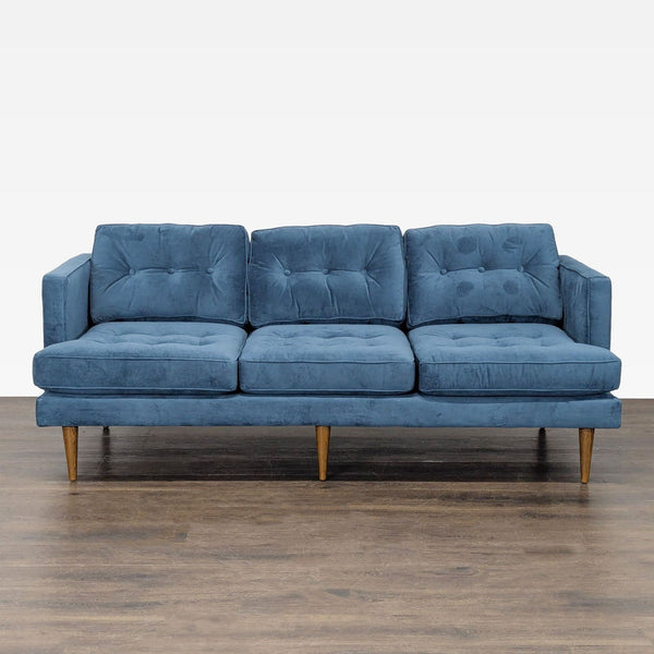 Modern blue 3-seat sofa with tufted cushions and wooden legs, ideal for living rooms.