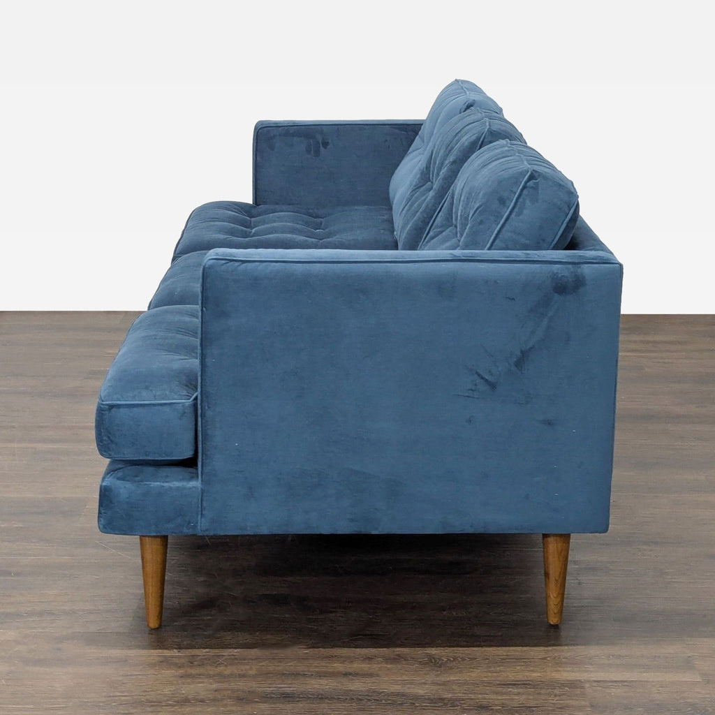 Blue upholstered 3-seat sofa featuring tufted seats and back, perfect for stylish comfort.