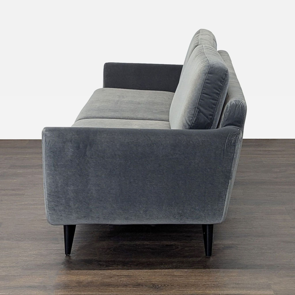 Contemporary dark gray Sits For Crate And Barrel 3-seater with plush cushions and stylish black legs.