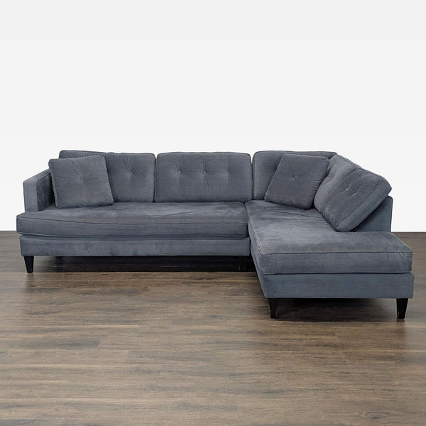 Gray L-shaped sectional with tufted cushions and ample seating, ideal for modern living rooms.