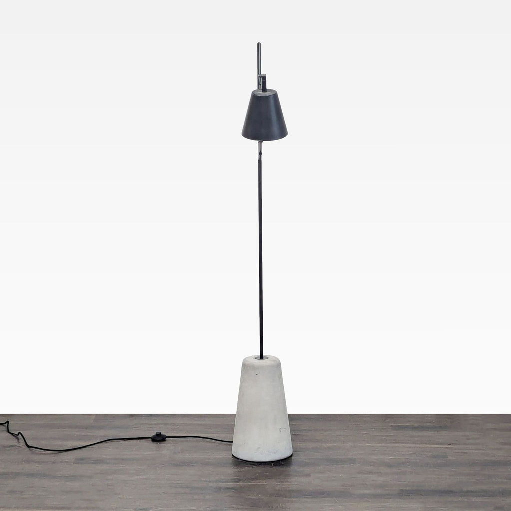 EQ3 black floor lamp with a concrete base and movable shade, perfect for targeted lighting in modern rooms.