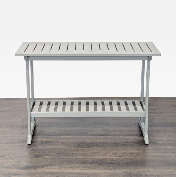 Compact gray Ikea side table with slatted top and lower storage shelf, ideal for small spaces.
