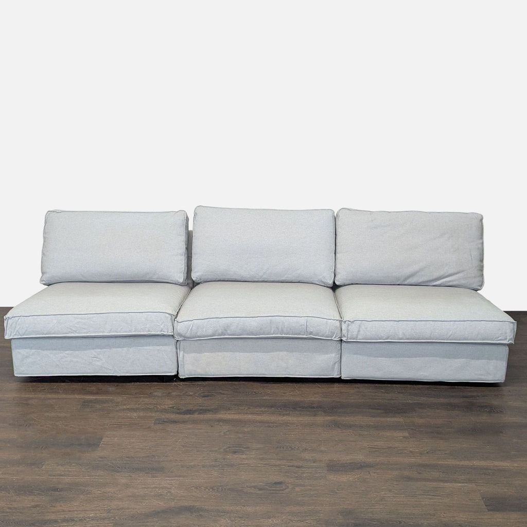 Light gray Ikea sectional sofa with modern design, seating three, suitable for various living rooms.