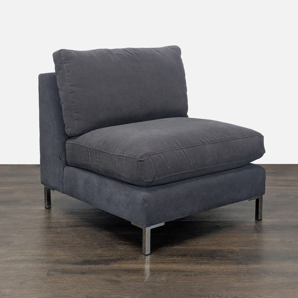 CB2 brand armless lounge chair with soft dark gray upholstery and sturdy metal legs, perfect for living rooms.