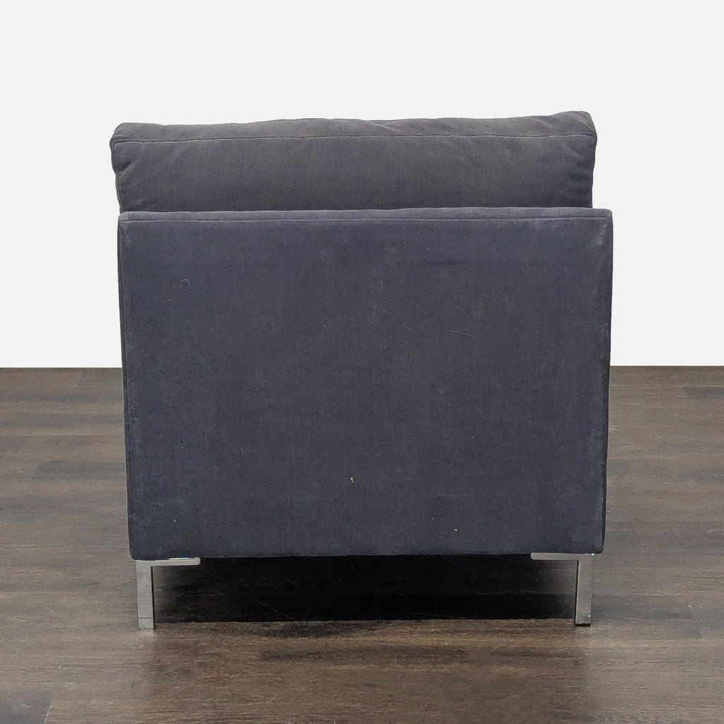 Contemporary lounge chair by CB2 featuring plush dark gray cushions and metal legs, designed for comfort.