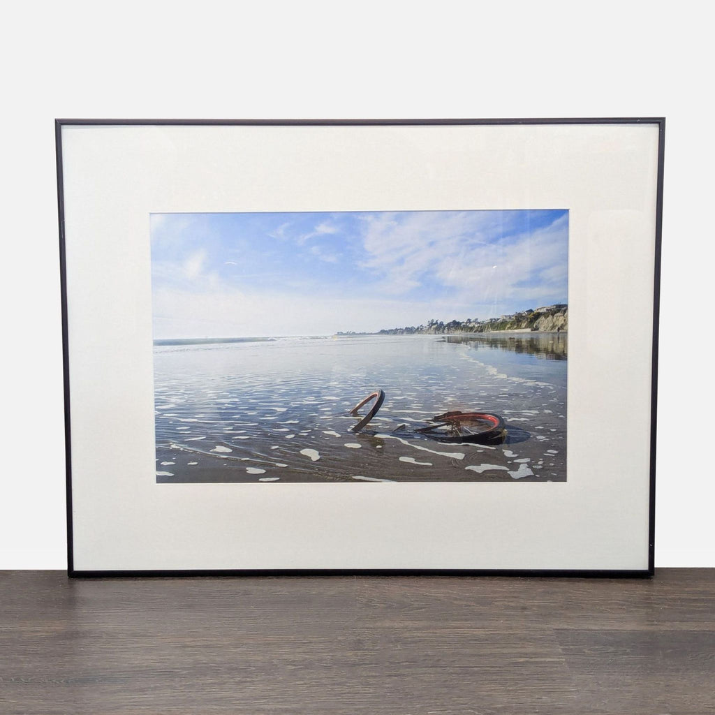 Framed Print – Abandoned Bicycle Wheel on Beach with Scenic View
