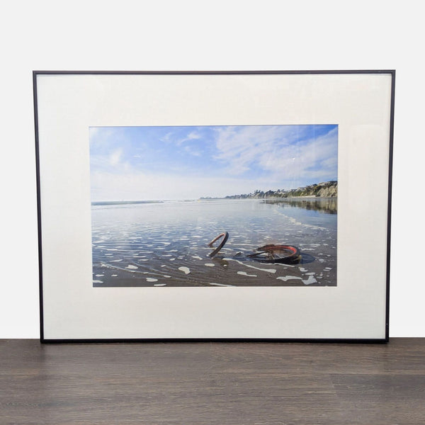 Framed Print – Abandoned Bicycle Wheel on Beach with Scenic View