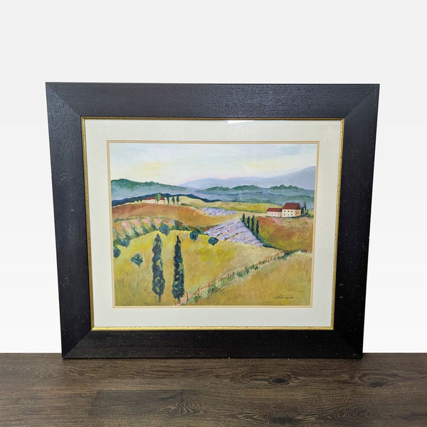 Framed landscape print by Kris Taylor, featuring hills, trees, and houses in a peaceful countryside scene.