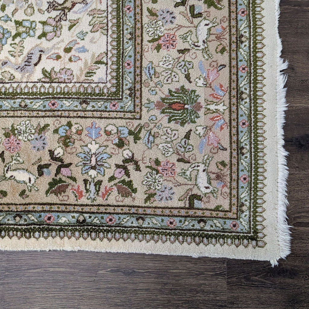 Ivory wool rug with sage, blue, blush, and taupe accents; displays classic tree, bird, and floral designs.