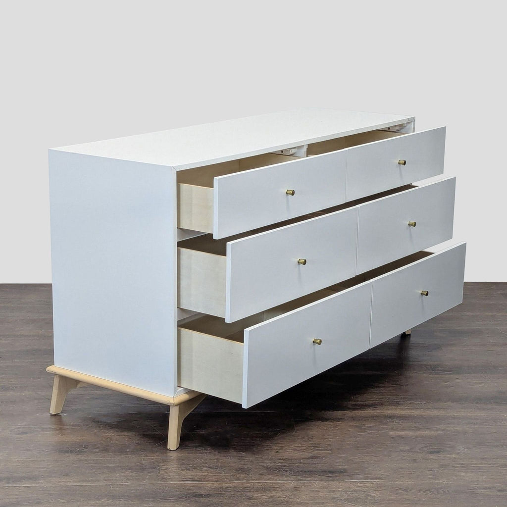 Sleek white West Elm dresser featuring six spacious drawers, gold hardware, and a sturdy wooden base.  