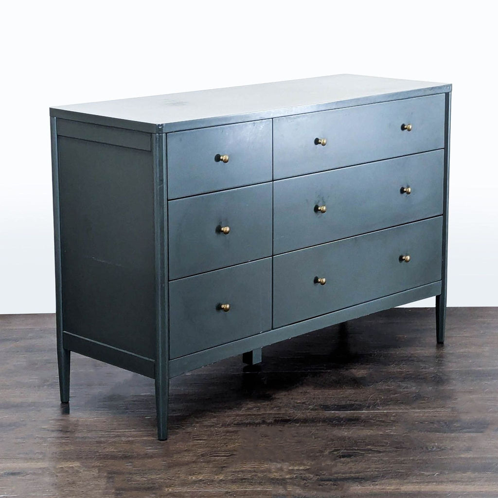 Contemporary dresser by Crate & Barrel featuring a smooth finish, gold knob accents, and ample storage space.  