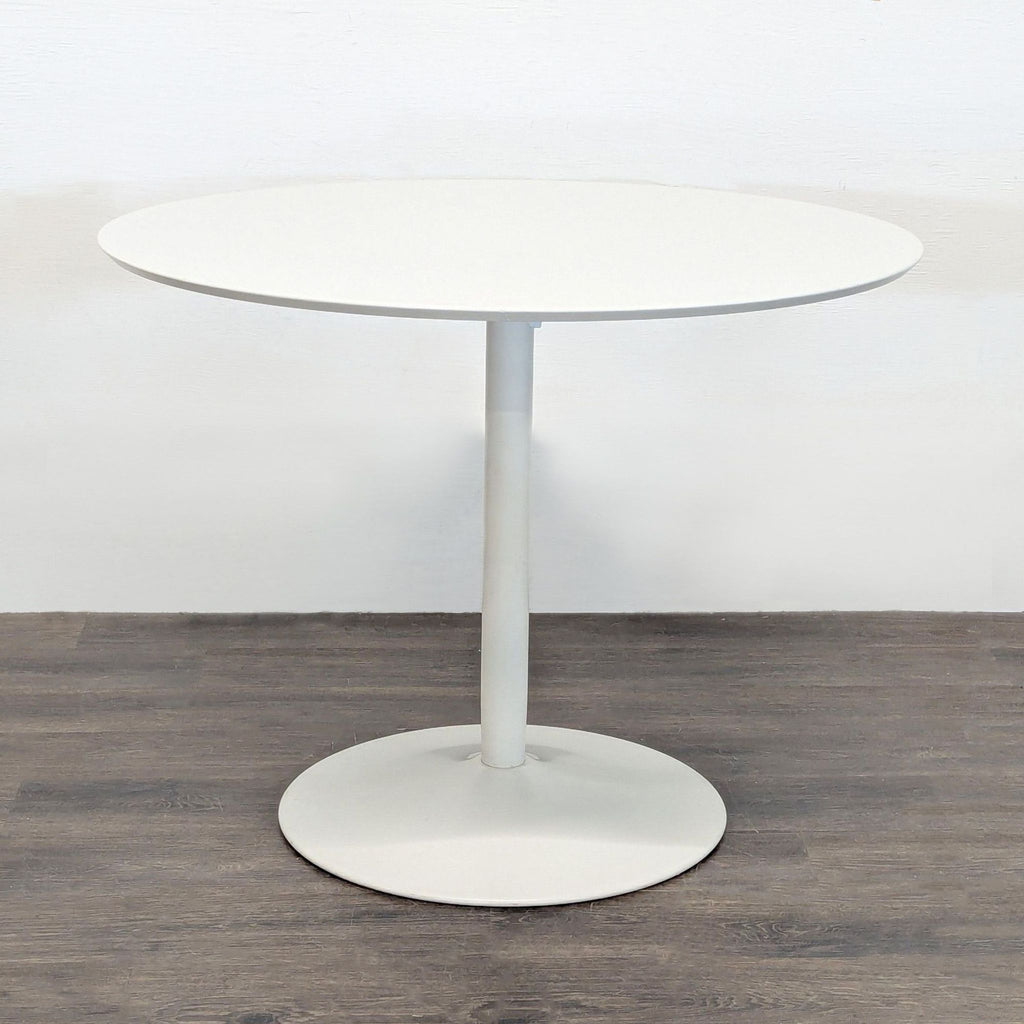 Modern white CB2 dining set: round table and four matching chairs with removable striped seat cushions included.  