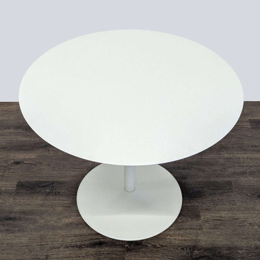 Contemporary CB2 dining set with sturdy white table and four chairs, perfect for apartments or small families.