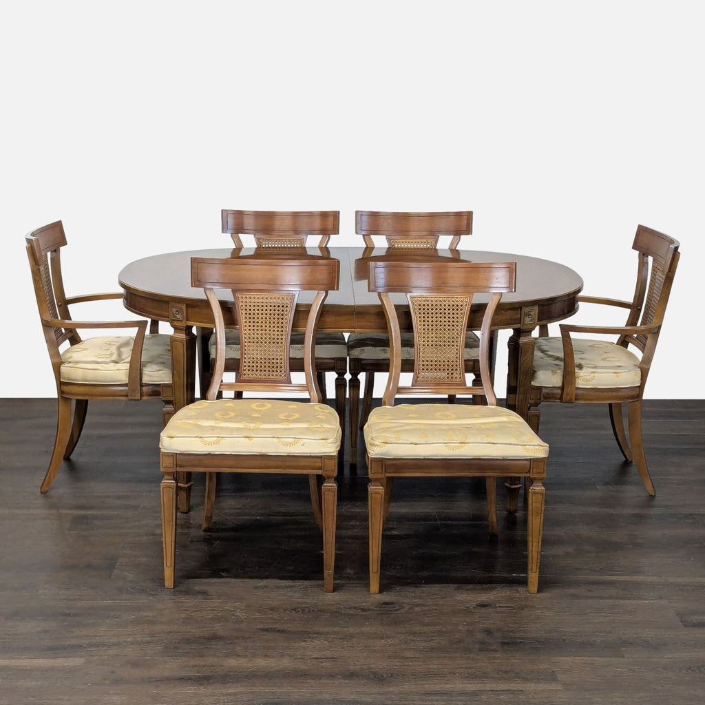 Thomasville oval dining table with three leaves and six cane-back chairs in warm walnut finish.