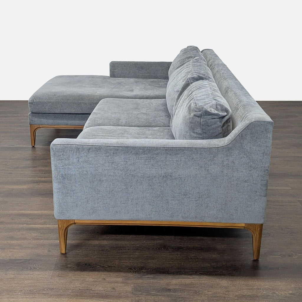 Sectional sofa by West Elm in gray fabric, offering comfort and style with a roomy chaise and sleek design.