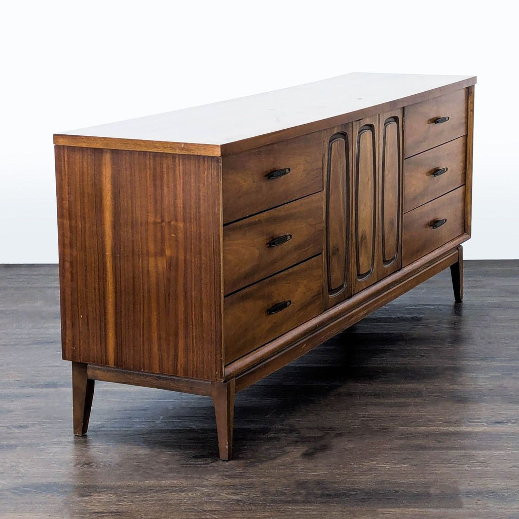 Vintage Broyhill credenza with symmetrical side drawers and center doors opening to extra storage drawers.