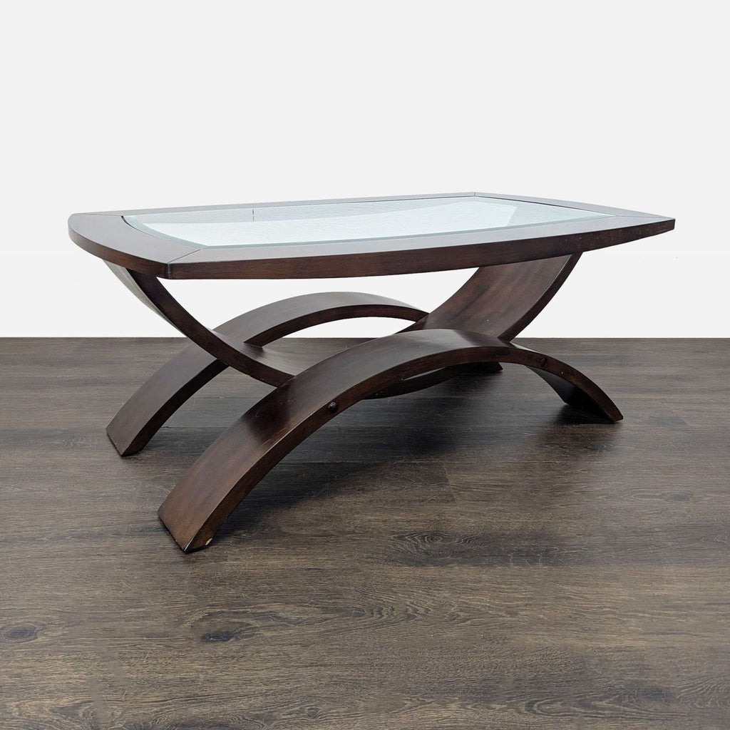 Modern coffee table from Magnussen Home with curved legs and beveled glass surface.