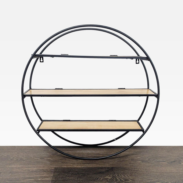 Modern round wall bookshelf with black metal frame and three wooden shelves for decor; World Market brand.