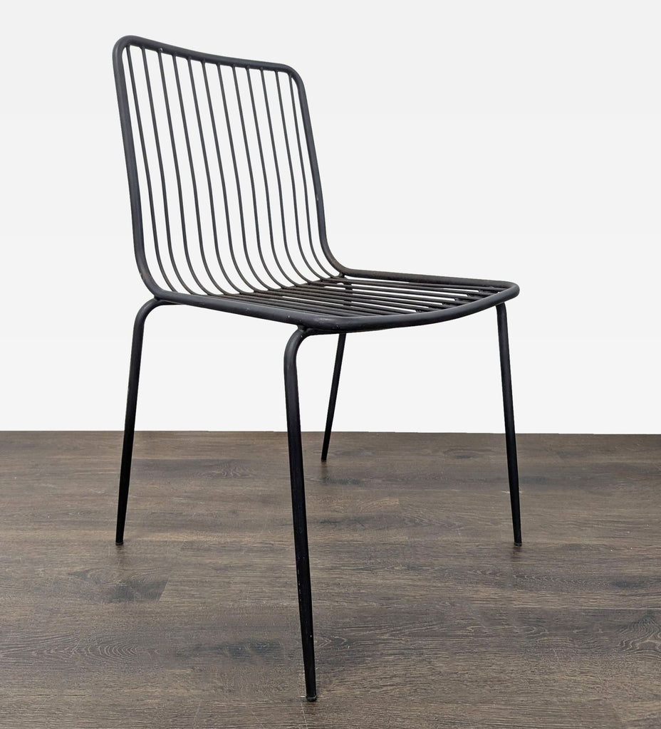 Lightweight, sturdy chair made of black metal wire, ideal for small rooms or as extra seating.