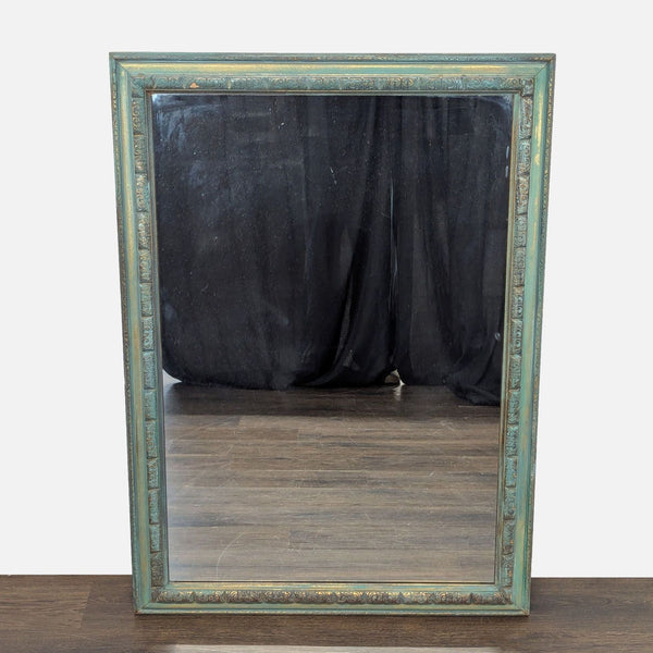 1. Rectangular mirror with a decorative, distressed turquoise and gold frame standing on a wooden floor.