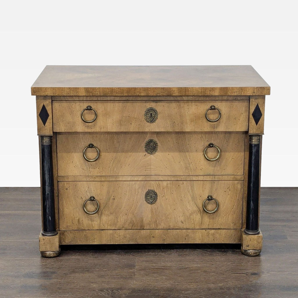 Baker Furniture dresser with three drawers, brass handles, black column accents, and decorative medallions.
