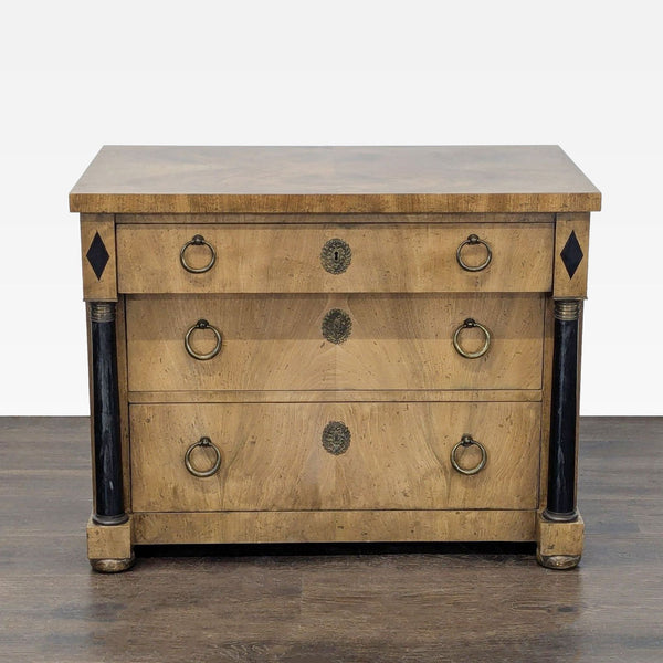Baker Furniture dresser with three drawers, brass handles, black column accents, and decorative medallions.