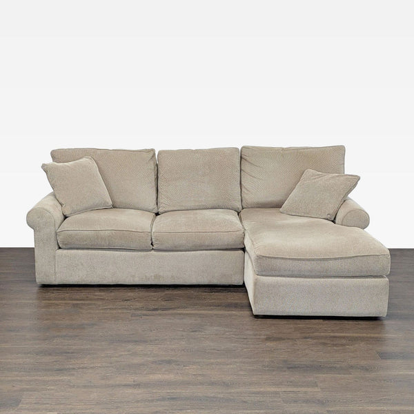 Cascadia beige sectional with chaise lounge, plush cushions, and two matching pillows in a modern style.