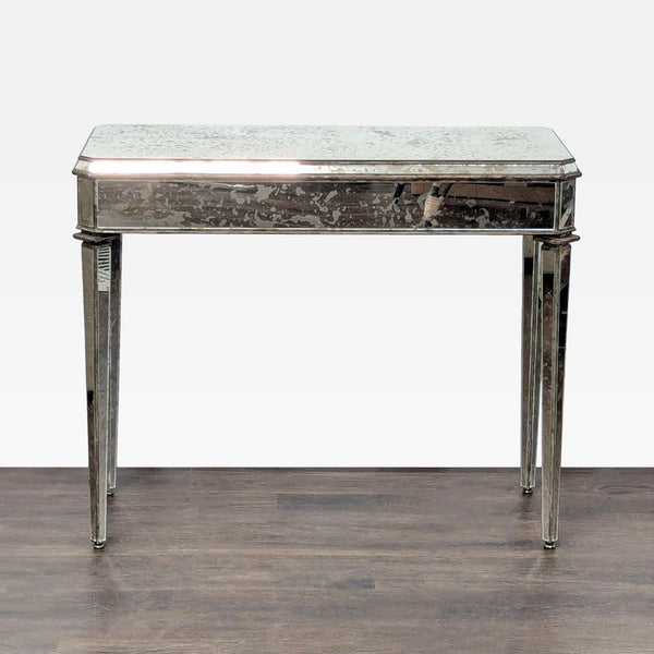Antiqued mirror side table with a single drawer and tapered pin legs by Currey & Company.