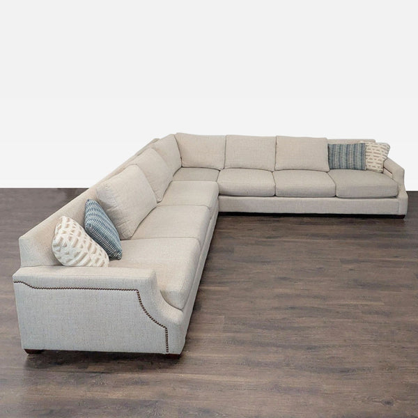 Havertys sectional sofa in beige with nailhead trim, deep cushions, and four accent pillows for modern comfort.
