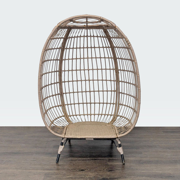 Egg-shaped rattan chair with metal legs, open weave design, suitable for indoor or outdoor relaxation.